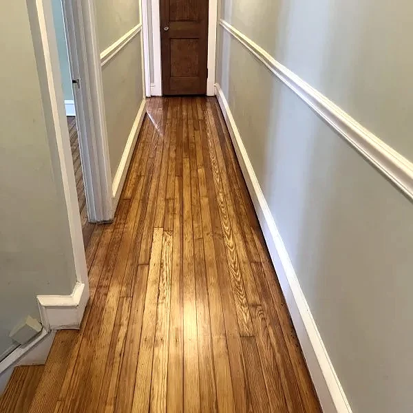 Solid hardwood flooring in residential hallway with natural wood grain