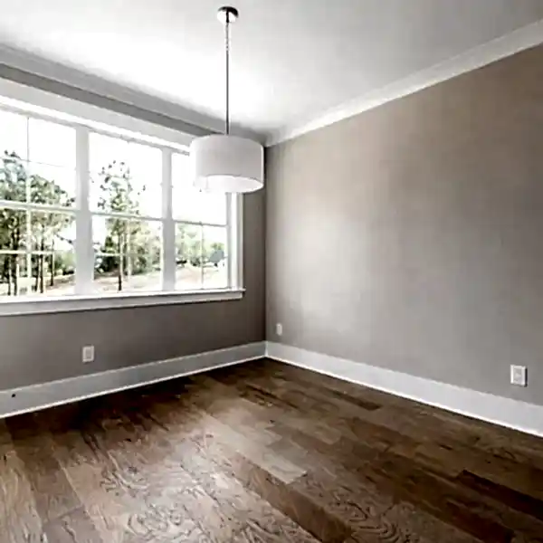Hardwood floor with subtle water damage, staining, and mild cupping near a window