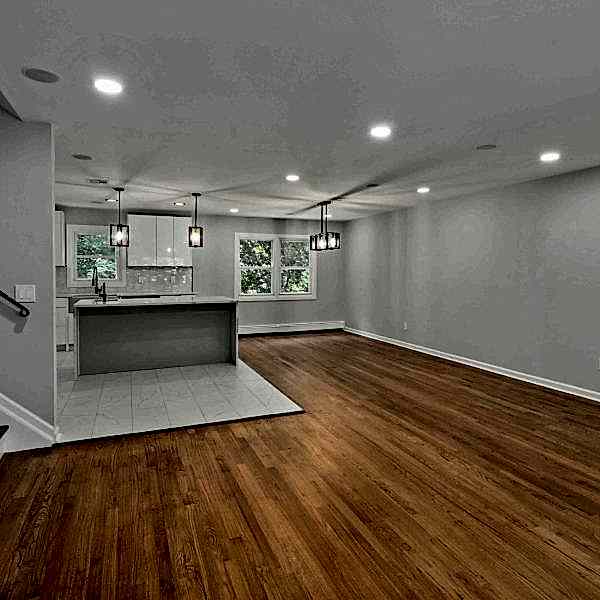 Open-plan-home-with-refinished-hardwood-floors-gray-walls-modern-kitchen-and-staircase-scaled.